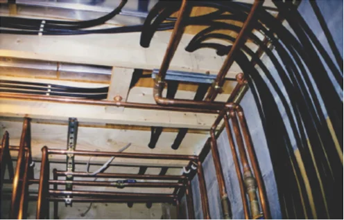 Small-diameter flexible hydronic tubing routed through framing cavities.